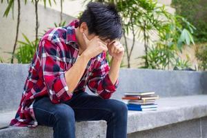 asiatique Masculin élèves étaient déçu avec le résultats de le entrée examen pour le université. tristesse et dérangé photo