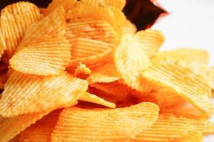 croustilles de pommes de terre dans un sac ouvert, délicieux assaisonnement pour barbecue épicé pour les frites, collations frites en tranches fines de restauration rapide. photo