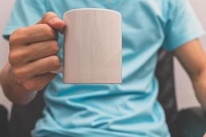 un homme tenant une tasse de café photo