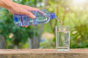 bouteille d'eau potable et verre avec fond naturel photo