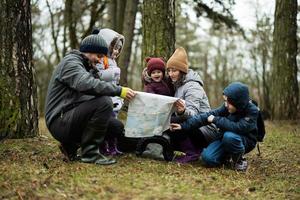 famille et des gamins avec carte dans le forêt. photo