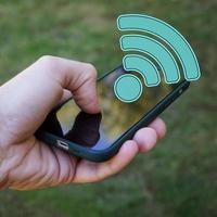 main en portant une intelligent téléphone avec Wifi icône, sans fil fidélité photo