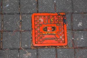 couvercle de trou d'homme du système de gazoduc. une trappe métallique massive pour l'accès aux communications de la ville dans le trottoir. photo