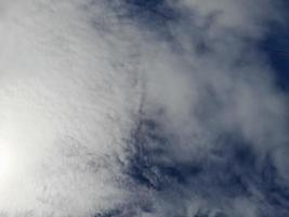 beaux nuages blancs sur fond de ciel bleu profond. de grands nuages doux et moelleux couvrent tout le ciel bleu. photo