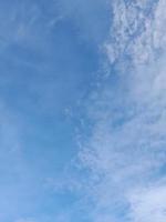 nuages blancs dans le ciel bleu. beau fond bleu clair. peu nuageux, beau temps. nuages bouclés par une journée ensoleillée. photo