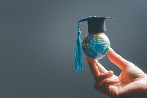 l'obtention du diplôme casquette avec Terre globe. concept de global affaires étude, à l'étranger éducatif, retour à école. éducation dans global monde, étude à l'étranger affaires dans les universités dans mondial. Langue étude photo