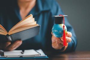 l'obtention du diplôme casquette avec Terre globe. concept de global affaires étude, à l'étranger éducatif, retour à école. éducation dans global monde, étude à l'étranger affaires dans les universités dans mondial. Langue étude photo