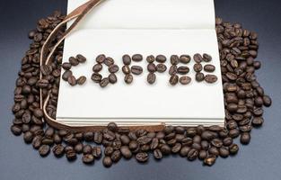 une livre avec une mots de café fabriqué par le rôti café des haricots avec isolé noir Contexte. photo