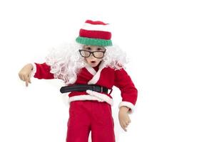 marrant enfant habillé comme Père Noël claus grimaces, pose, chante rap.noel peu garçon dans une chapeau et lunettes. photo