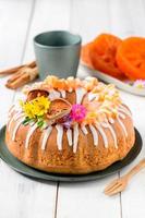 Bael fruit gâteau décoré avec petit fleurs sur Haut sur blanc bois arrière-plan, photo