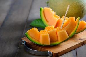 tranche de Japonais melons, Orange melon ou cantaloup melon sur bois photo
