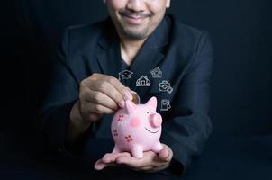 homme d'affaire en mettant argent pièce de monnaie dans porcin pour économie argent avec les dépenses Icônes photo