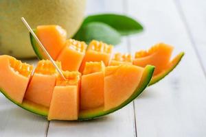 tranche de Japonais melons, Orange melon ou cantaloup melon sur blanc bois photo