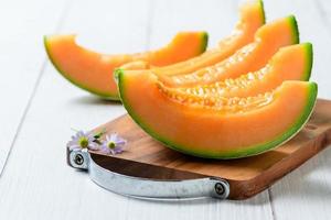 tranché de Japonais melons mon chéri melon ou cantaloup cucumis melo sur blanc en bois photo