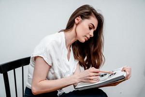 fille séance sur une chaise dessine une esquisser pour une image photo