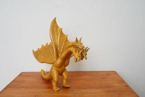d'or dragon gidorah isolé sur blanc Contexte. sur en bois table photo