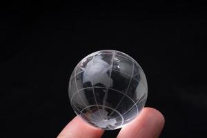 verre de cristal de globe terrestre à la main. commerce et économie mondiale. concept environnemental ou écologique photo