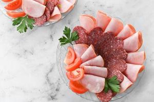 assiette avec un assortiment de bouilli, fumé saucisse sur brillant tableau. photo