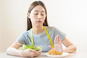 régime, suivre un régime asiatique Jeune femme ou fille pousser dehors, Nier frit poulet, déchet nourriture et choisir Frais des légumes salade de bol, manger nourriture pour bien en bonne santé, santé lorsque affamé. femelle poids perte gens photo