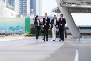 les gens d'affaires marchent et se parlent devant un bureau moderne photo