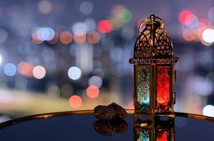 lanterne et Rendez-vous fruit avec nuit ciel et ville bokeh lumière Contexte pour le musulman le banquet de le saint mois de Ramadan Karim. photo