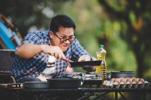 portrait d'homme voyageur asiatique lunettes friture de steak de porc photo