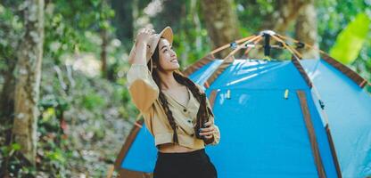 jeune femme applaudir et boire une boisson devant la tente de camping photo