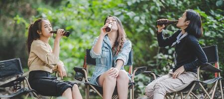 groupe de femmes buvant de la bière et des pieds trempés dans le ruisseau photo