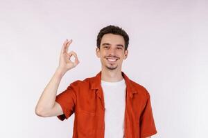 portrait de jeune homme pointant du doigt l'espace de copie isolé sur fond de studio blanc photo