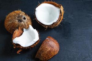 Noix de coco coupée en deux sur un fond de tableau noir photo