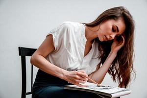 fille séance sur une chaise dessine une esquisser pour une image photo