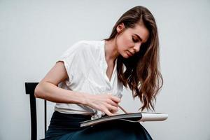 fille séance sur une chaise dessine une esquisser pour une image photo