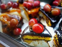 petit tranché Triangle forme Chocolat Gâteaux Garniture avec Frais rouge les raisins prêt pour vente dans le Portugal Pâtisserie magasin photo