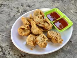 une assiette de frit Dumplings avec sauces et une vert assiette avec le mot frit sur il. photo