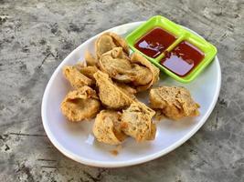 une assiette de frit Dumplings avec sauces et une vert assiette avec le mot frit sur il. photo