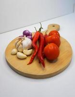 ail, le Chili, rouge oignon et tomates sur une en bois Coaster, haute angle tir. photo