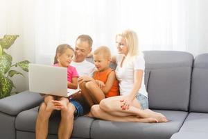 magnifique souriant multiéthique famille dans de face de le portable vidéo appel avec loin Parents à maison. photo