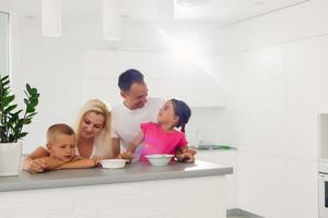 Jeune famille dans le blanc cuisine photo