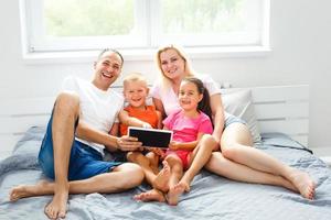 magnifique souriant multiéthique famille dans de face de le portable vidéo appel avec loin Parents à maison. photo