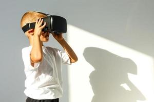 les enfants expérience virtuel réalité isolé sur blanc Contexte. surpris peu garçon à la recherche dans vr lunettes. photo