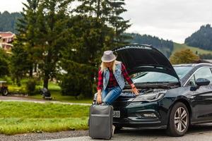 femme touristique sur le route cassé vers le bas une voiture photo