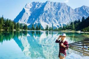 branché Jeune fille avec sac à dos profiter le coucher du soleil sur de pointe de Montagne. touristique voyageur sur Contexte vallée paysage vue maquette, lumière du soleil dans voyage dans basque pays, moquer en haut pour texte. photo