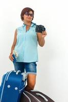 Jeune femme prêt à vacances avec caméra, papier carte et valise. photo