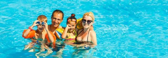 content famille avec deux des gamins ayant amusement dans le nager bassin. été vacances concept photo