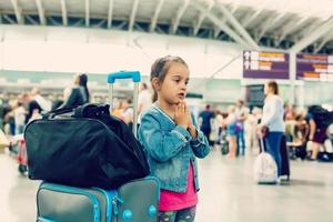 peu fille avec valise Voyage dans le aéroport, des gamins Voyage photo