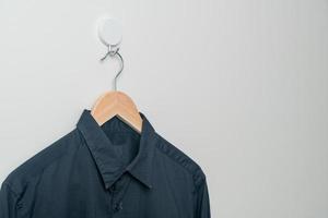 chemise suspendue avec cintre en bois au mur photo