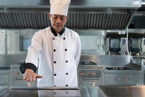 le chef a à contrôle le chaleur de le le fourneau juste droite à gril le steak donc cette le maturité de le Viande est selon à le clients le désir photo