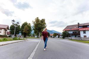 Jeune femme est permanent par en bois Maisons. village dans montagnes. voyage, mode de vie concept. Alpes, L'Europe . photo