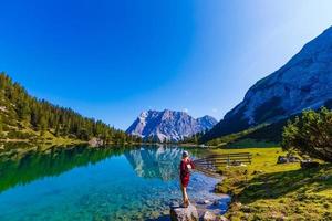 femme profiter beauté de la nature à la recherche à Montagne. aventure voyage, L'Europe . femme des stands sur Contexte avec Alpes. photo