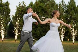 le premier Danse de le jeune marié et la mariée dans une court mariage robe sur une vert Prairie photo